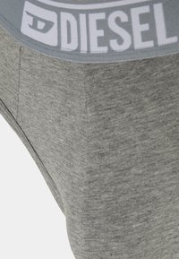Grå bomuldsundertøj med en glat tekstur, der har en lys grå elastik med logoet "DIESEL" i hvid.