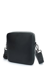 Borsa a tracolla nera in pelle con forma quadrata, chiusura a zip, tracolla regolabile e branding discreto sul davanti. Tessuto liscio.