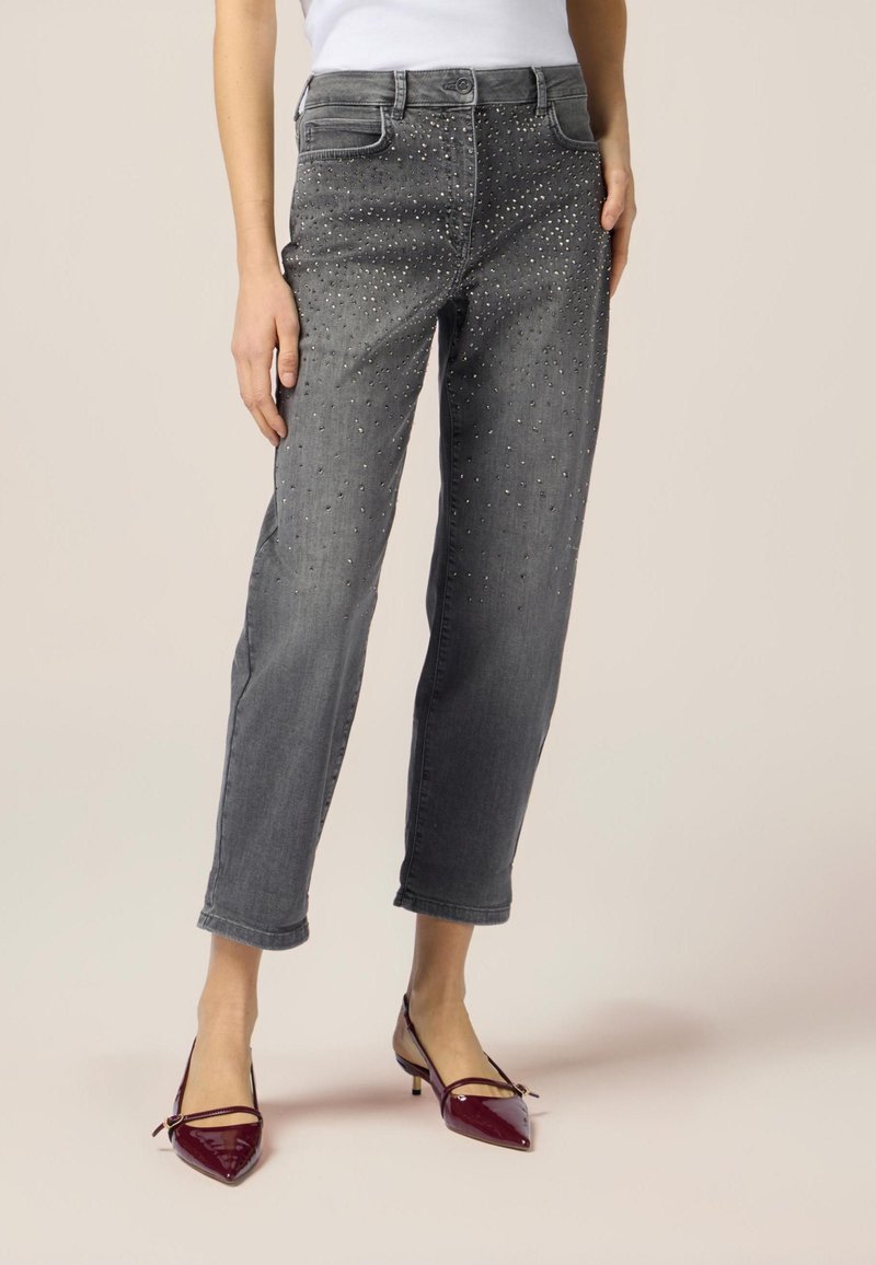 I jeans grigi presentano una vestibilità ampia, arricchiti con borchie argentate sul davanti. Il tessuto è denim, con gamba cropped e un classico design a cinque tasche.