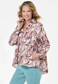 Floral-patterned shirt jacket featuring soft pink, purple, and green hues, with a collar, front button closure, and side pockets.