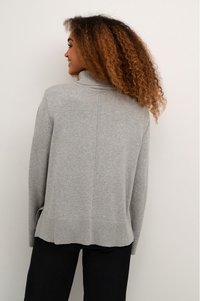 Grauer gestrickter Pullover mit hohem Kragen, geripptem Saum und seitlichen Schlitzen. Weiche Textur und lässige Passform. Mit einem subtilen Nahtdetail auf der Rückseite.