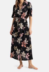 Robe maxi noire à fleurs avec des manches courtes, présentant des motifs de fleurs roses, blanches et dorées, un devant à boutons et une taille nouée.