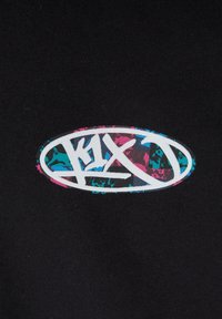 Czarna tkanina z białym owalnym logo z napisem "K1X" w graffiti, zdobionym różowymi i turkusowymi plamami.