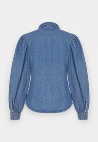 Veste en denim avec un col structuré, des manches bouffantes et un dos ajusté. Couleur bleu clair avec une texture subtile et des poignets à boutons.