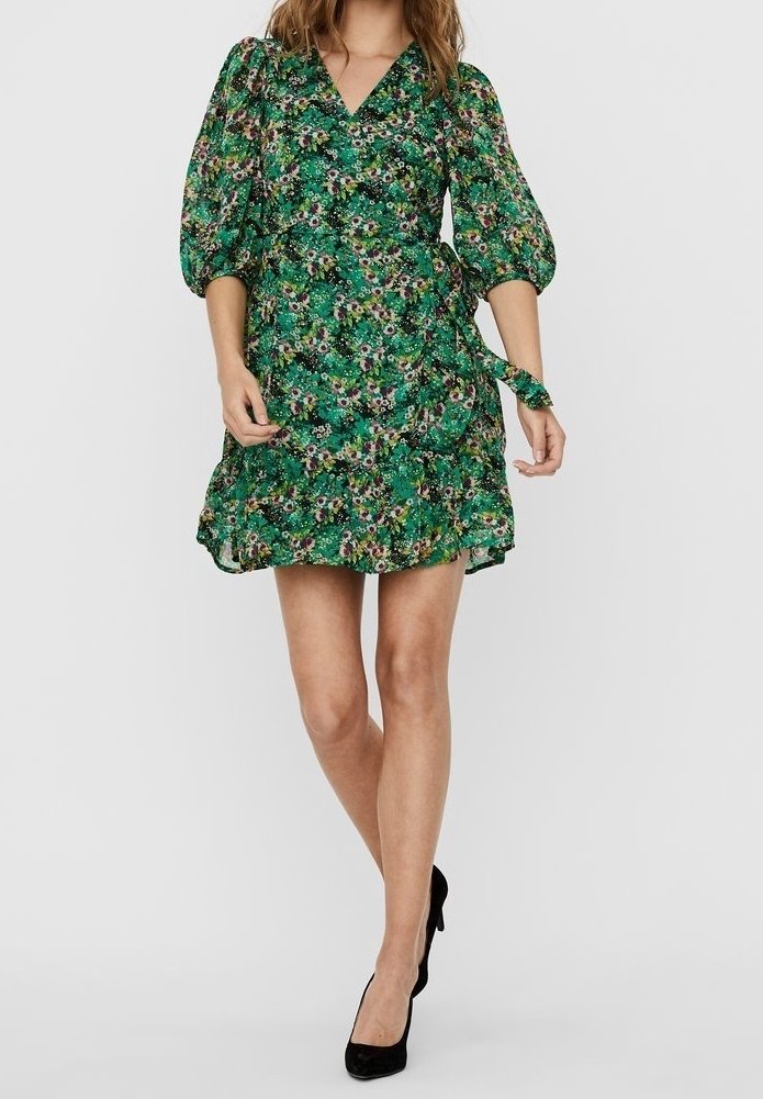 Robe à imprimé floral vert avec décolleté en V, manches bouffantes et ourlet à volants. Dispose d'une ceinture à nouer sur le côté. Le tissu a une texture légère.