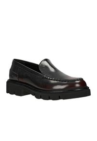 Černé kožené loafers s hladkým povrchem, podrobným prošíváním podél okraje a silnou černou gumovou podrážkou.
