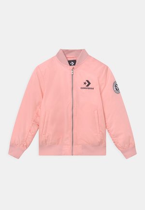 Giacca bomber rosa chiaro con cerniera, collo e polsini a costine, logo Converse nero sul petto e toppa circolare sulla manica sinistra.