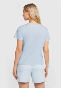 Light blue cotton t-shirt with short sleeves, a crew neckline, and a relaxed fit, shown worn with matching light blue shorts.
