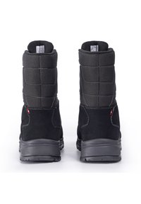 Des bottes d'hiver en suède noir et en tissu présentent un design matelassé, une semelle en caoutchouc grise et des coutures contrastantes avec un petit patch décoratif.