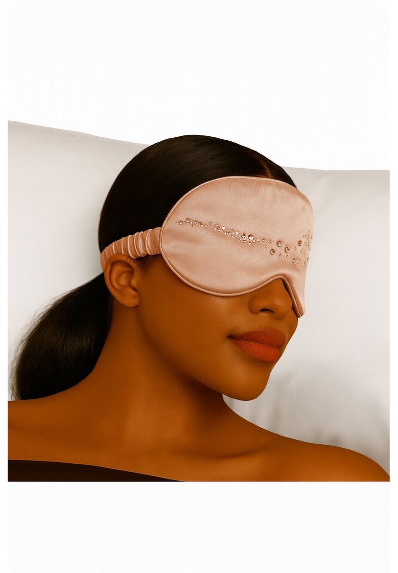Różowa satynowa maska na oczy do spania z elastycznym paskiem, ozdobiona przezroczystymi kamieniami ułożonymi w falisty wzór na przedzie.