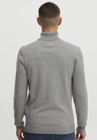 Heled hall pullover-sviiter, mis on valmistatud pehmest kudumist. Omab kõrget kaelust ja ribatud mansette, sileda tekstuuri ja keha lähedast lõiget.