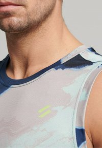Débardeur de sport sans manches en gris clair avec des motifs abstraits bleus et verts, fabriqué en tissu en maille respirant et avec un col rond.