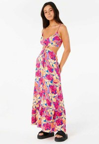 Robe maxi florale arborant un motif rose, orange et bleu, nouée à la taille avec un design découpé, fabriquée en tissu léger.