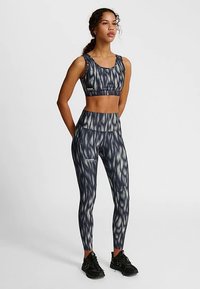 Sport-bh och leggingsset i mörkblått med ett vågmönster. Tillverkat av ett stretchigt tyg, med hög midjeresår och figurnära passform.