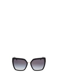 Ochelari de soare negri în stil cat-eye, cu lentile degradate, rame din plastic groase și accente aurii roz. Prezintă un design unghiular și o formă proeminentă.