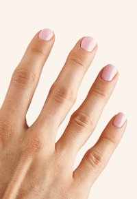 Mano con cinque dita che mostra una pelle liscia e uno smalto rosa chiaro. Le unghie sono lucide con una finitura uniforme e bordi arrotondati.