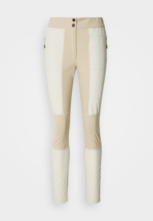 Beige and cream-colored pants with a panel design, featuring a zipper pocket, two buttons at the waistband, and a fitted silhouette.