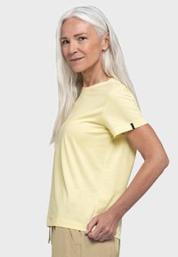 Gelbes Baumwoll-T-Shirt mit kurzen Ärmeln, rundem Ausschnitt und lockerer Passform. Verfügt über ein kleines Markenetikett am linken Ärmel.