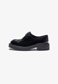 Scarpe stringate in pelle verniciata nera con suola in gomma nera spessa e texturizzata e dettagli di cucitura delicati lungo il bordo della suola.