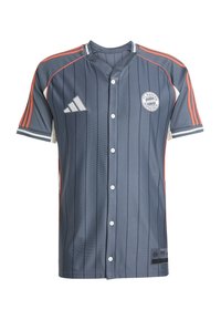 Maillot gris à rayures fines en tissu respirant. Dispose de bandes rouges sur les côtés et d'un devant boutonné. Logo du FC Bayern München sur la poitrine.