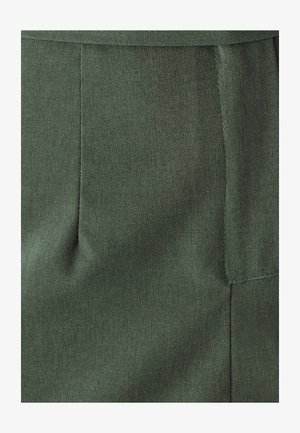 Tmavozelená látka s hladkým povrchom, obsahujúca záhyb a detailné šitie pozdĺž okrajov. Dizajn zahŕňa jednoduchý, elegantný strih.