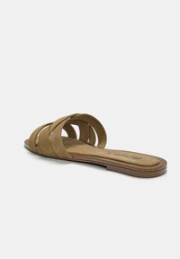 Brown suede slide sandal featuring multiple overlapping straps and a flat cork sole, with a cushioned insole for comfort.
