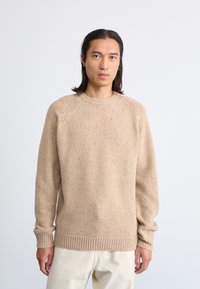 Beige Strickpullover mit Rundhalsausschnitt, Raglanärmeln und gerippten Bündchen. Verfügt über eine gesprenkelte Textur. Lässige Passform.
