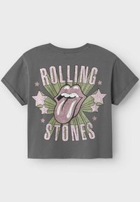 Grå kortärmad T-shirt med en stor tunglogotyp och texten "ROLLING STONES" i rosa, med gröna strålar och rosa stjärnor i bakgrunden.