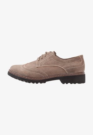 Chaussure oxford en suède brun avec un bout rond, perforations décoratives, coutures contrastées et une semelle en caoutchouc texturée.