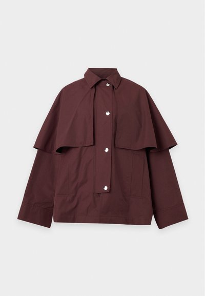 Veste marron foncé à boutons avec large cape sur les épaules, manches longues, col et deux poches latérales, posée à plat sur fond blanc.
