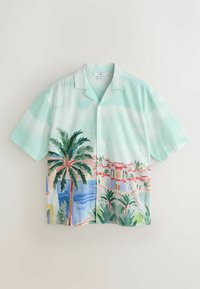Chemise vert menthe à manches courtes avec un motif aquarelle représentant une ville côtière, des palmiers et une mer bleue sous un ciel nuageux.