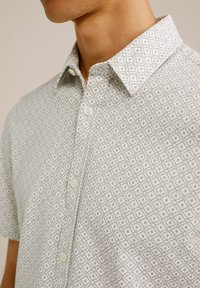 Kortekogige shirt in lichtgrijs met een geometrisch ruitenpatroon, button-down kraag en witte knoopsluitingen. Katoenen materiaal.