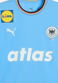 Himmelblaues Sporttrikot aus glattem Gewebe, mit großem weißen "atlas"-Text, Puma-Logo, Lidl-Patch und Emblem des Deutschen Handballverbands.