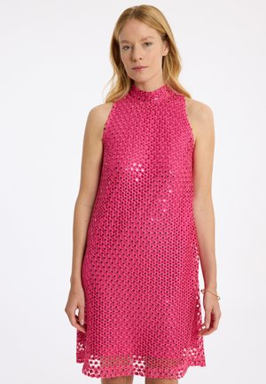 Roze mouwloze jurk met een hoge halslijn, voorzien van een uitsnijding en metalen accenten. Lichtgewicht, gestructureerde stof met een vloeiende silhoeet.