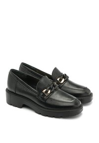 Czarne skórzane mokasyny o teksturowanym wykończeniu, z żółtą łańcuchem na wierzchu stopy i masywną, teksturowaną podeszwą.