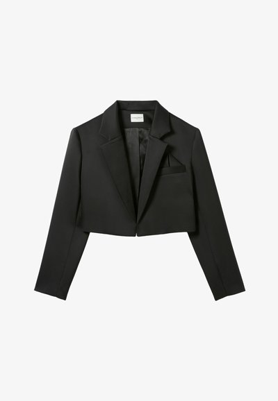 Blazer negro cortado hecho de tela suave. Presenta un collar con muesca, un bolsillo en el pecho y mangas estructuradas. No se observa detalle de cierre.