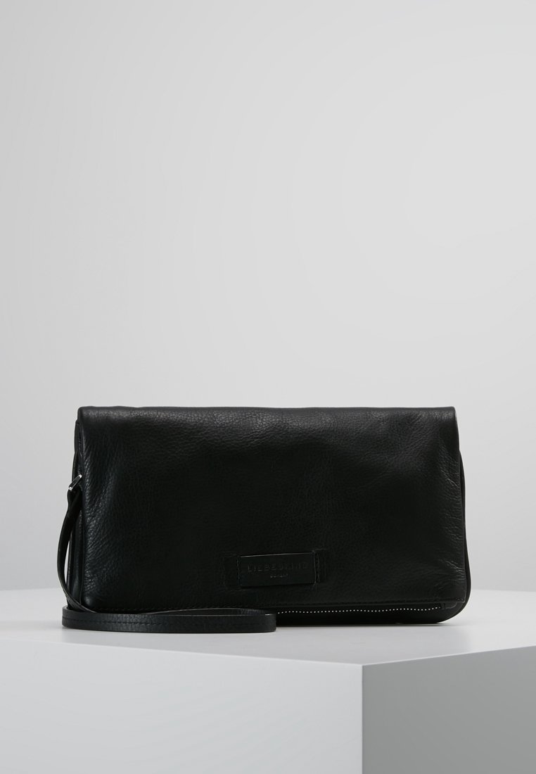 Černá kožená kabelka na zápěstí s texturovaným povrchem, klopovým uzávěrem a nastavitelným popruhem. Obsahuje nášivku s logem a kontrastní švy.