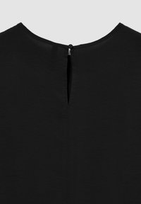Top nero con scollatura tondeggiante, dotato di un'apertura a forma di chiave sul retro, fissata con un bottone. Texture liscia e design semplice.