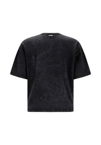 Sort oversized t-shirt med korte ærmer med et diskret præget dragedesign på ryggen og et lille rektangulært mærke nær halsudskæringen.