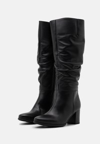 Black leather knee-high boots with a slouchy design, rounded toe, and a chunky heel, featuring a smooth texture and minimal stitching details.