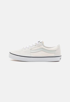 Zapatillas bajas de ante blanco con una franja lateral azul claro, cordones blancos, puntera redonda y suela de goma negra con un medialuna blanca.