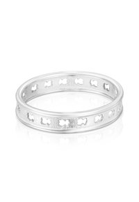 Anello d'argento con piccoli ritagli a forma di farfalla ripetuti intorno alla fascia, esposto su una superficie bianca riflettente.