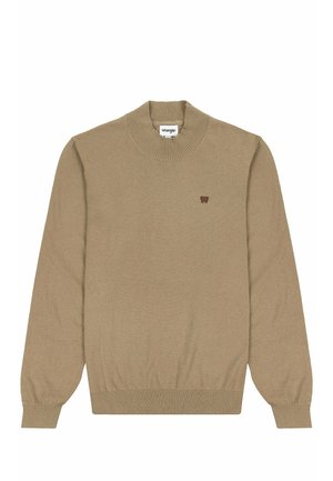 Beżowy dziany sweter z żeberkowym dekoltem i mankietami. Posiada mały brązowy emblemat logo na lewej piersi. Miękka faktura i klasyczny krój.