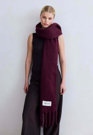 Bordeaux wollen sjaal met franjes, voorzien van een wit label met de tekst "ARCTIC FOX." Zachte textuur en brede, vallende vorm.