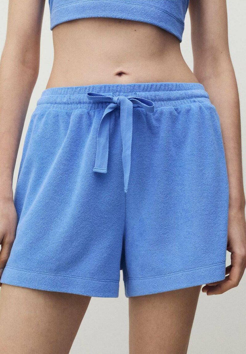 Ljust blå terrykloth-shorts med elastisk midjeband, justerbar dragsko och lös passform, med en mjuk textur och minimal detaljering.
