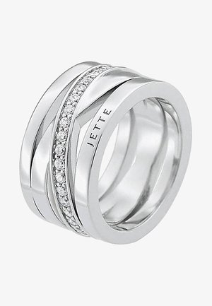 Drei ineinandergreifende metallische Ringe in Silber, mit einem zentralen Band, das eine Reihe kleiner klarer Steine zeigt, glatte und polierte Oberfläche.