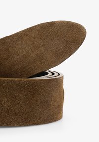 Cinturón de ante marrón con una superficie suave y texturizada; se enrolla de manera ordenada con una punta redondeada. Presenta una hebilla metálica discreta.