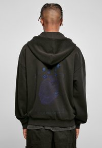 Black hooded sweatshirt featuring a graphic design of a head and butterflies in blue and purple, with "STAY OPEN MINDED" text.