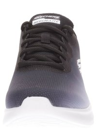 Zapatilla textil negra con parte superior de malla, punta redonda, suela blanca y cordones. Presenta la marca Skechers en la lengüeta y el lateral.