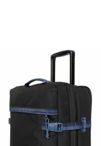 Valise à roulettes noire avec une finition texturée, fermeture éclair bleue et sangles à boucle. Elle présente une poignée noire rétractable et une poignée de transport latérale.